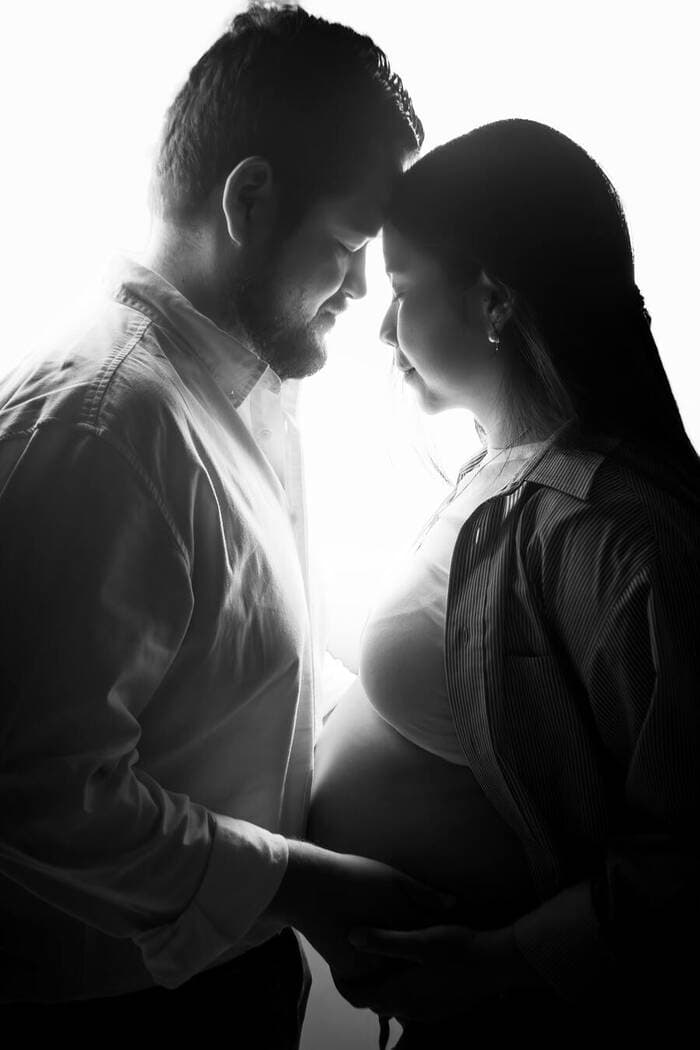 Pareja embarazada a contraluz, blanco y negro